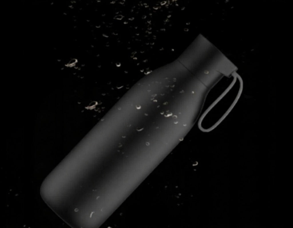 Black water bottle with handle on a black background