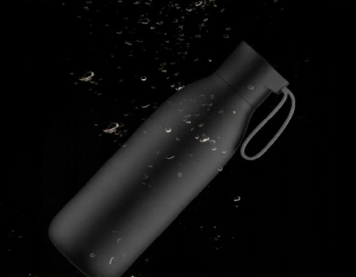 Black water bottle with handle on a black background
